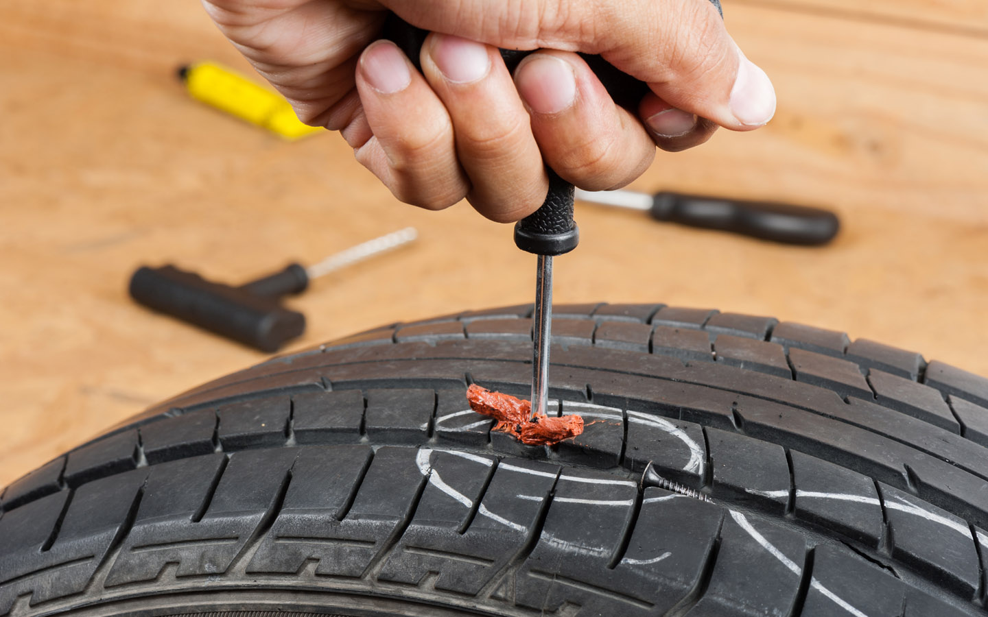 how to plug a leaky tyre: putting a wire in tyre with tool
