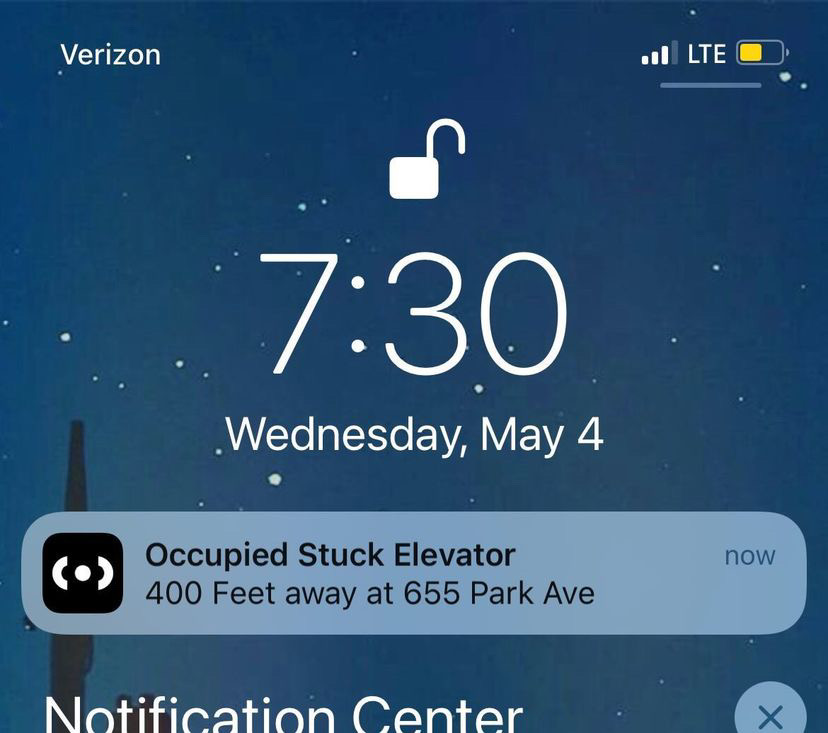 The image is a screenshot of the Citizen's app notification on someone's phone. The notification alerts to an "occupied stuck elevator," 400 feet away at 655 Park Ave. 