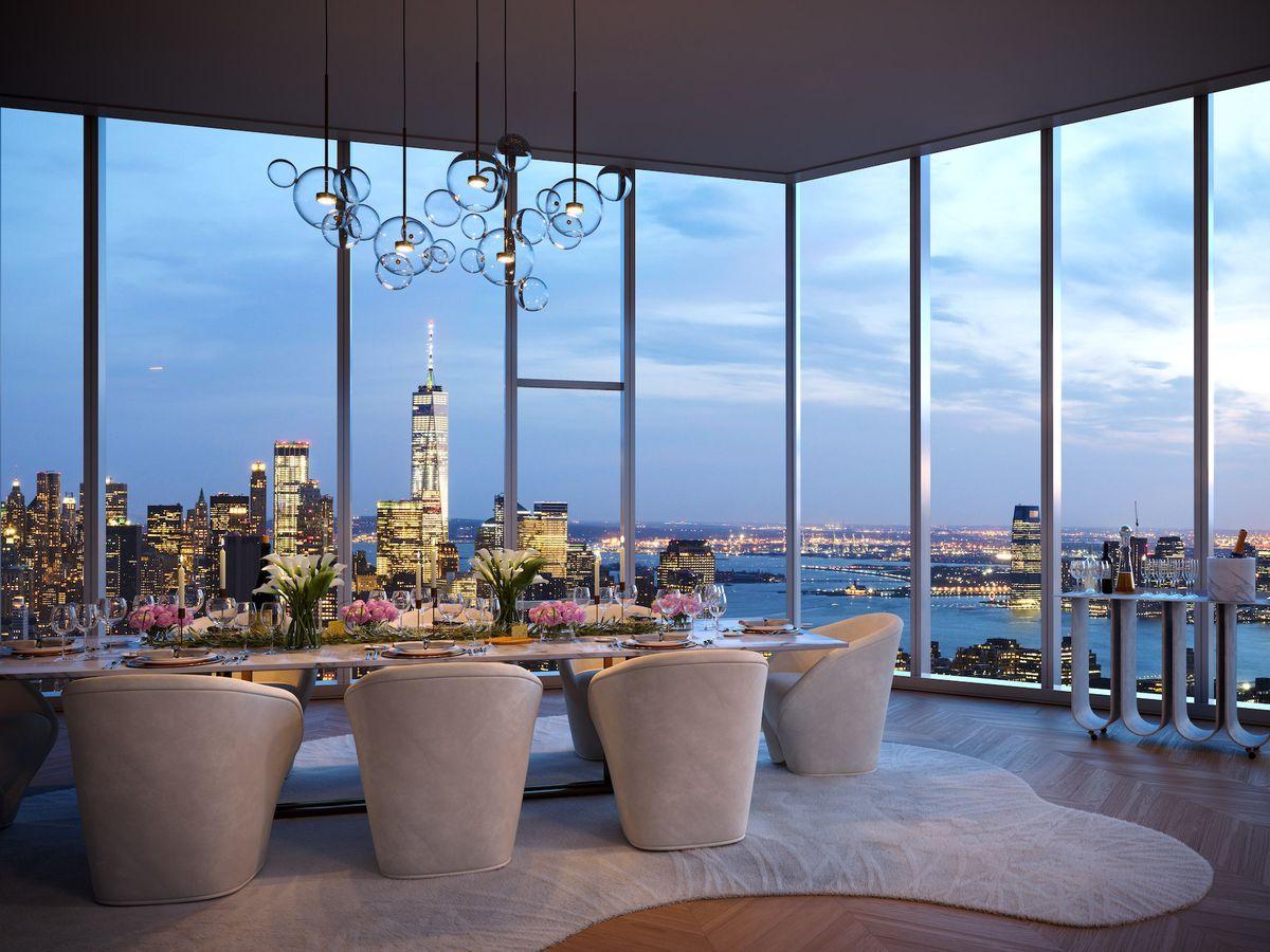 A living area. There is a large table with many chairs. There are floor to ceiling windows overlooking the New York City skyline.