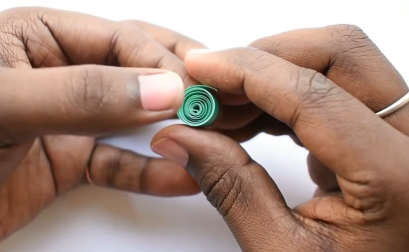 Dùng một tờ giấy quilling màu xanh lá, cuộn tròn như hình để dùng làm lá nhé. (Nguồn: Youtube)