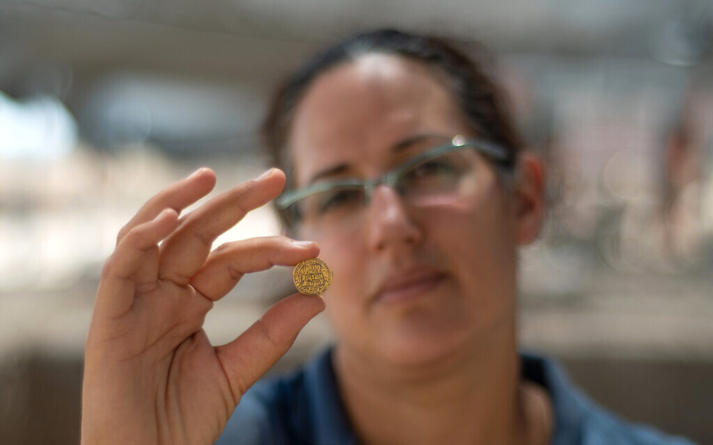 Liat Nadav-Ziv, director of the excavation, with the gold cache (Yoli Schwartz, Israel Antiquities Authority)