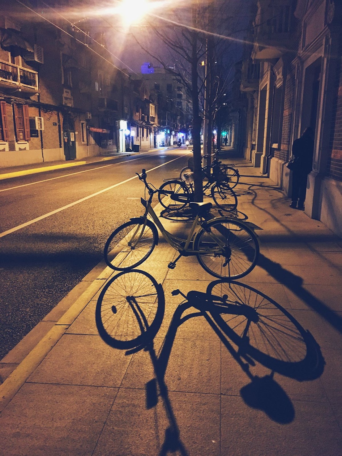 Bicycled parked on sidewalk at night