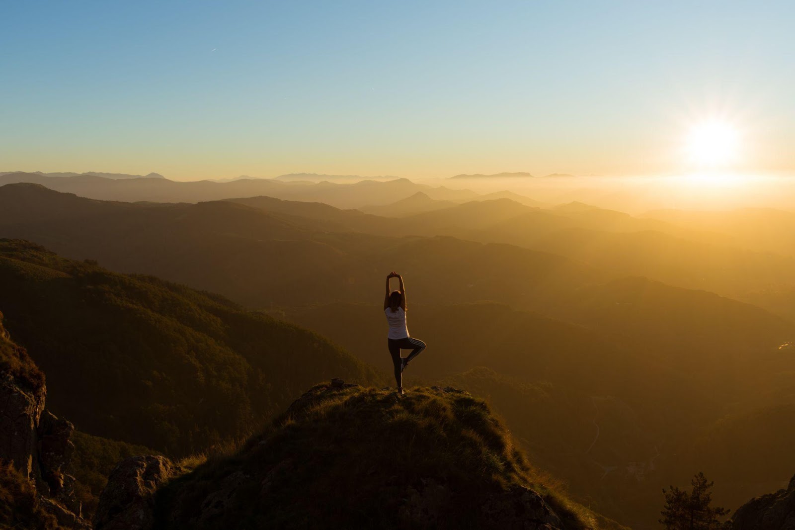 we can overcome social anxiety at work through relaxation shows a woman on top of a mountain