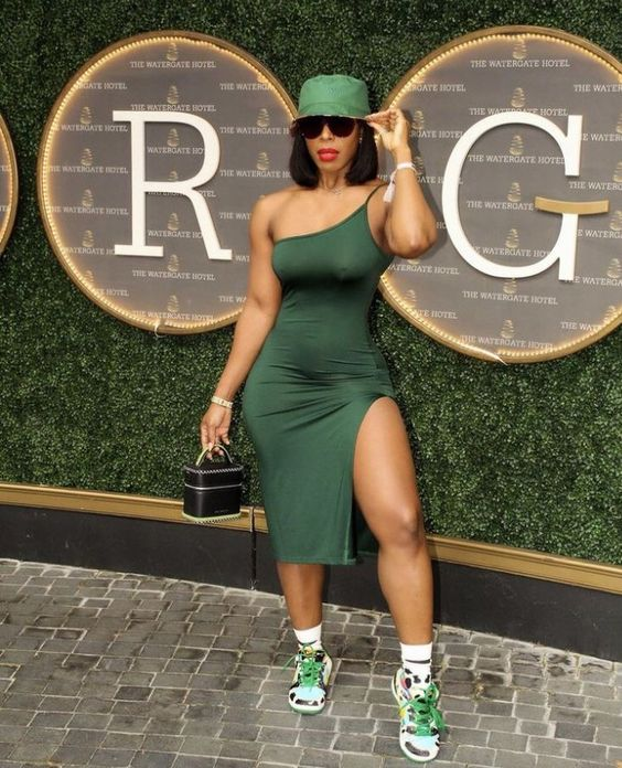 lady wearing green bucket hat with dark green dress and sneakers