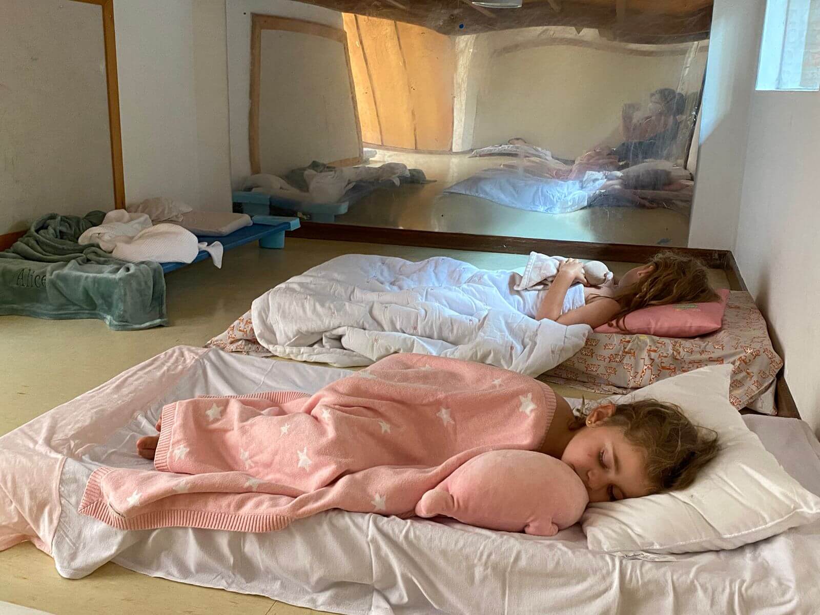 A imagem mostra 2 crianças dormindo.