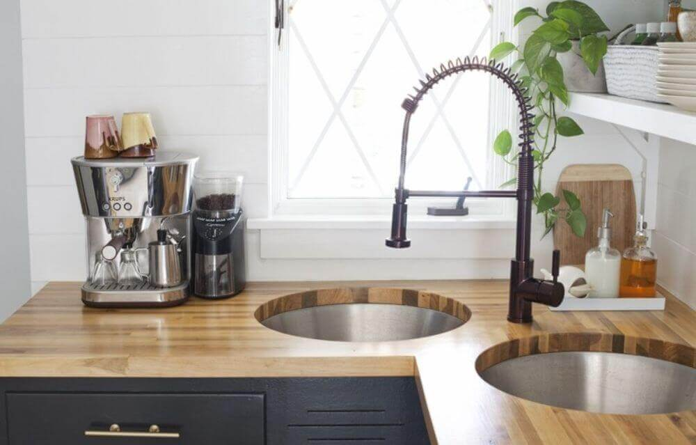 modern double basin corner sink with modern faucet and wood countertops