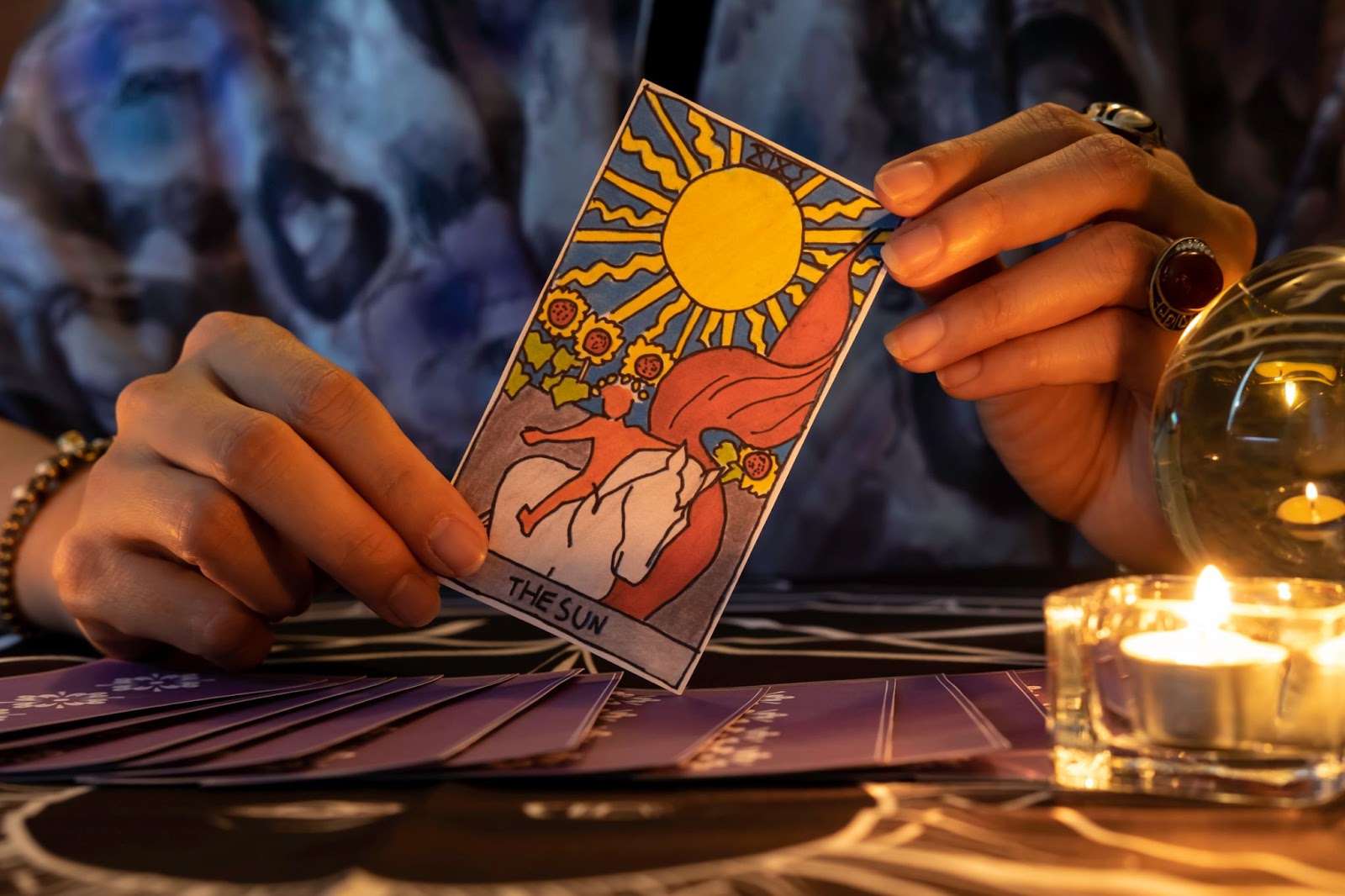 A tarot card reader holding the card "the sun" in her hands. 