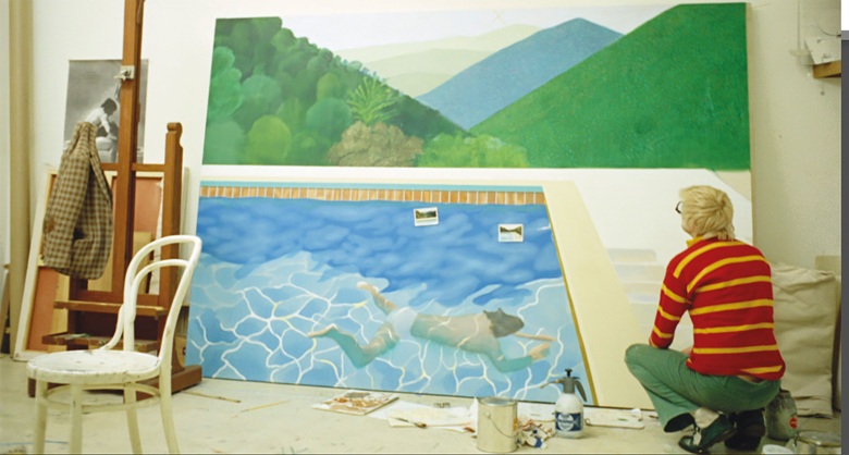 Hockney worked 18 hours a day non-stop for two weeks to finish his painting, finally completing it the night before it was due to be shipped to New York. Film still from A Bigger Splash, 1974 (present lot in progress illustrated). Photo Jack Hazan Buzzy Enterprises Ltd. Artwork © David Hockney