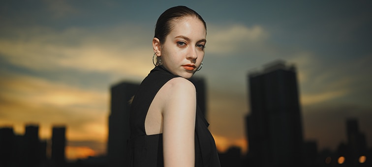 Image of a woman posing with a building in the background