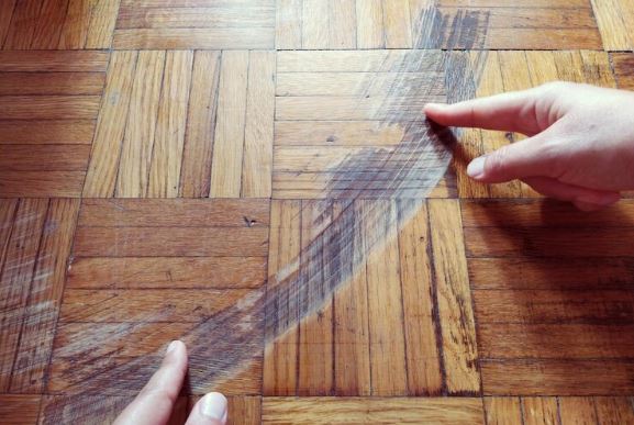 What damages can happen to wooden floors while removing Carpet tape?
