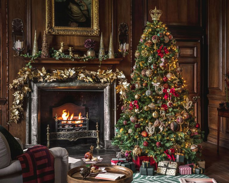 classic Christmas tree near to a fireplace