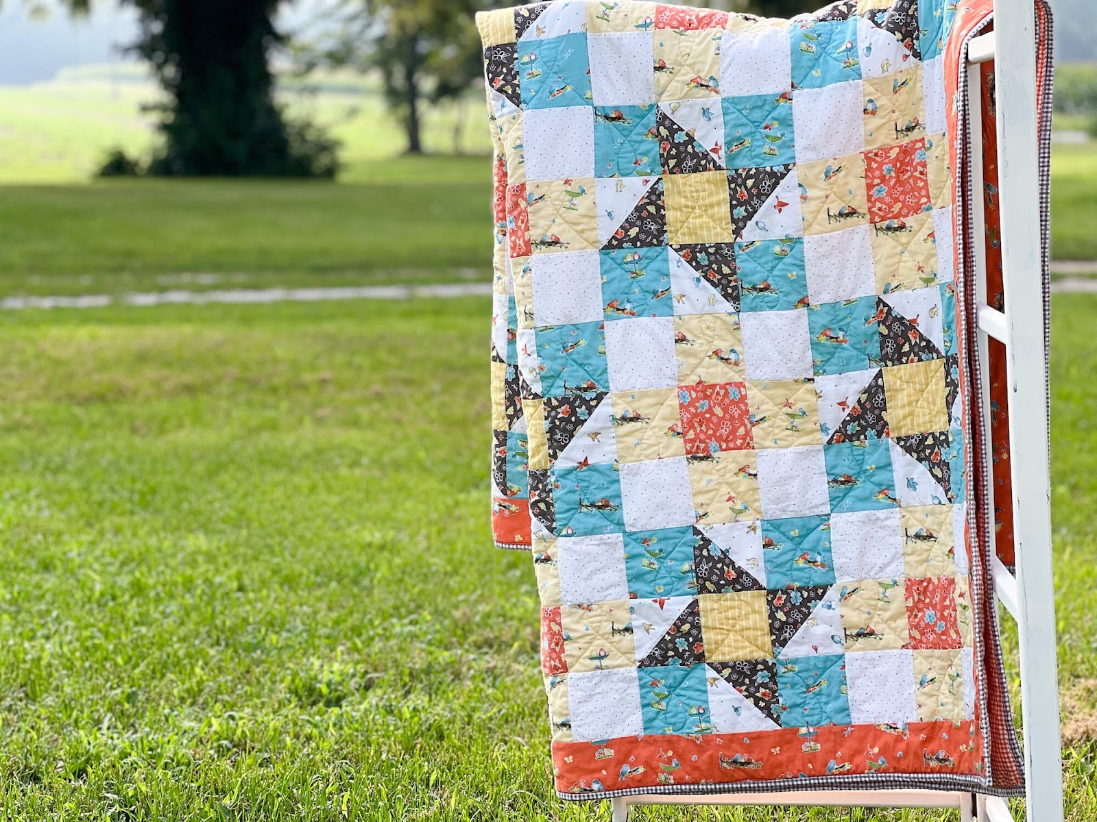 quilt on quilt rack in grass