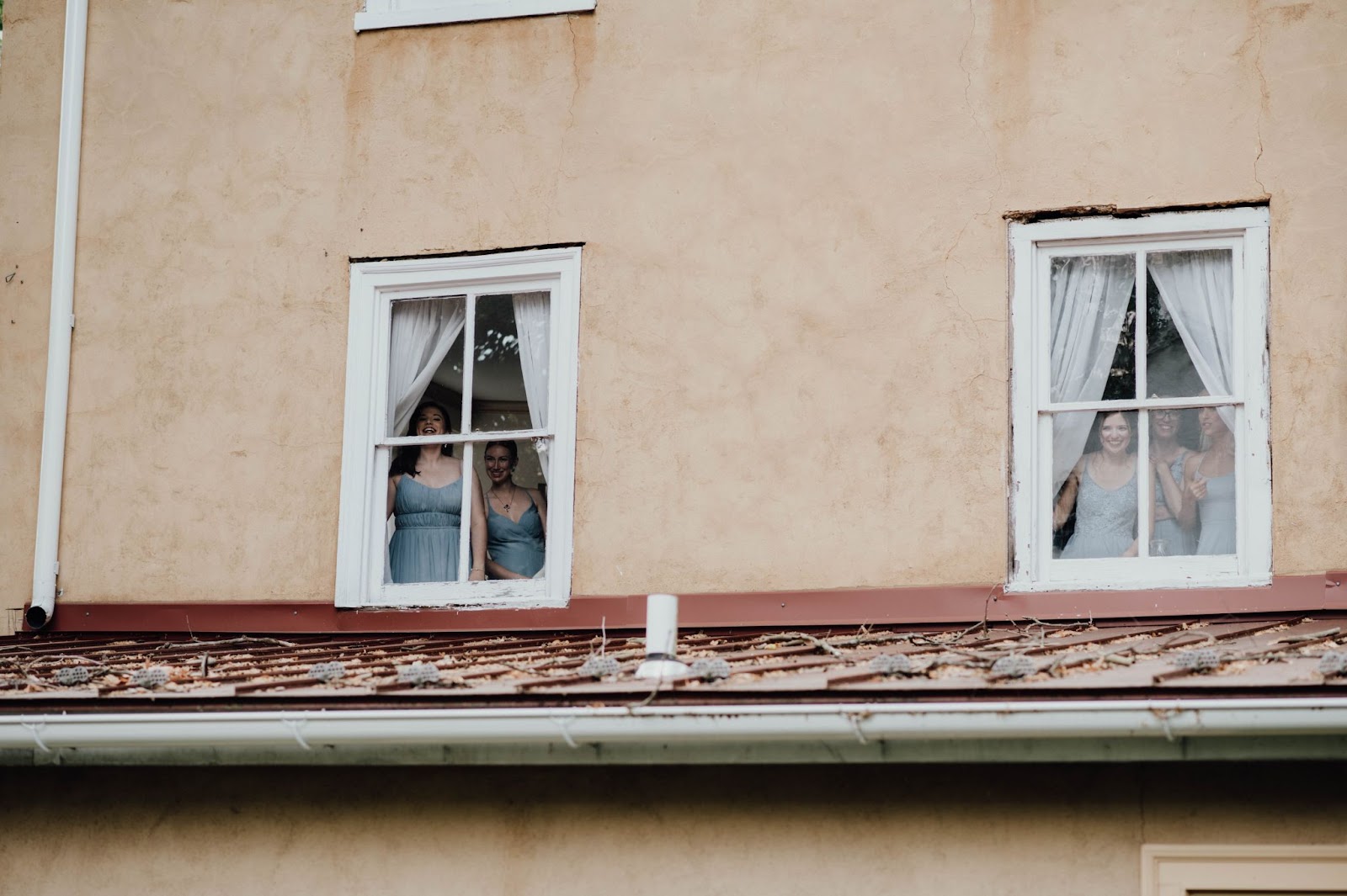 Wondering how to find a wedding photographer? Look out for key moments captured in their portfolios like bridesmaids peeking out at the bride and groom during their first look.