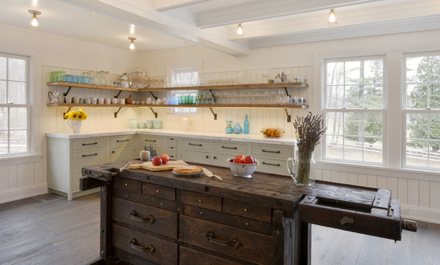 This farmhouse kitchen in Bedford, New York was designed with a “barn feel” in mind. An antique carpenter’s workbench was restored by the builder, for use as an island and extra work station.