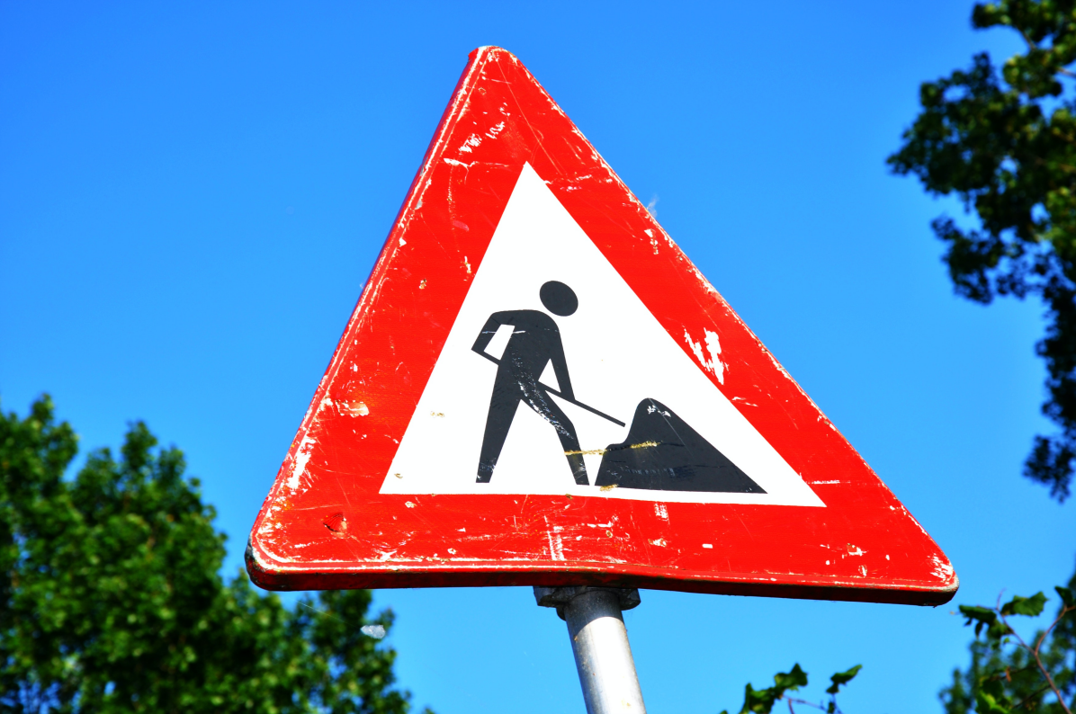 A red and white sign with a black image on it

Description automatically generated