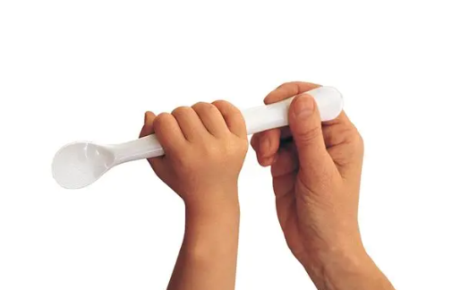 A close-up of a baby's hand holding a spoon

Description automatically generated