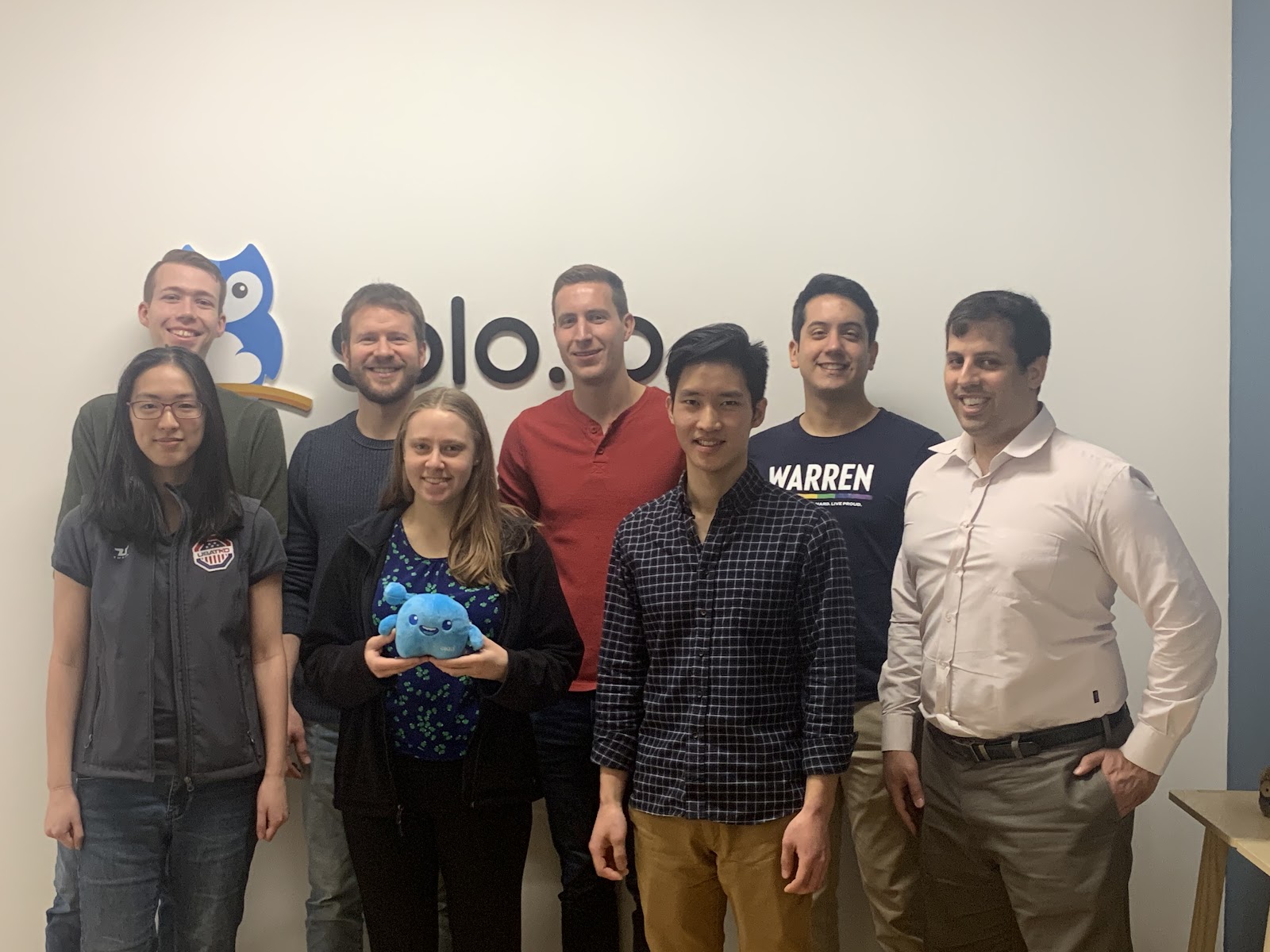 Solo.io’s team gathers for a group photo next to the company’s logo