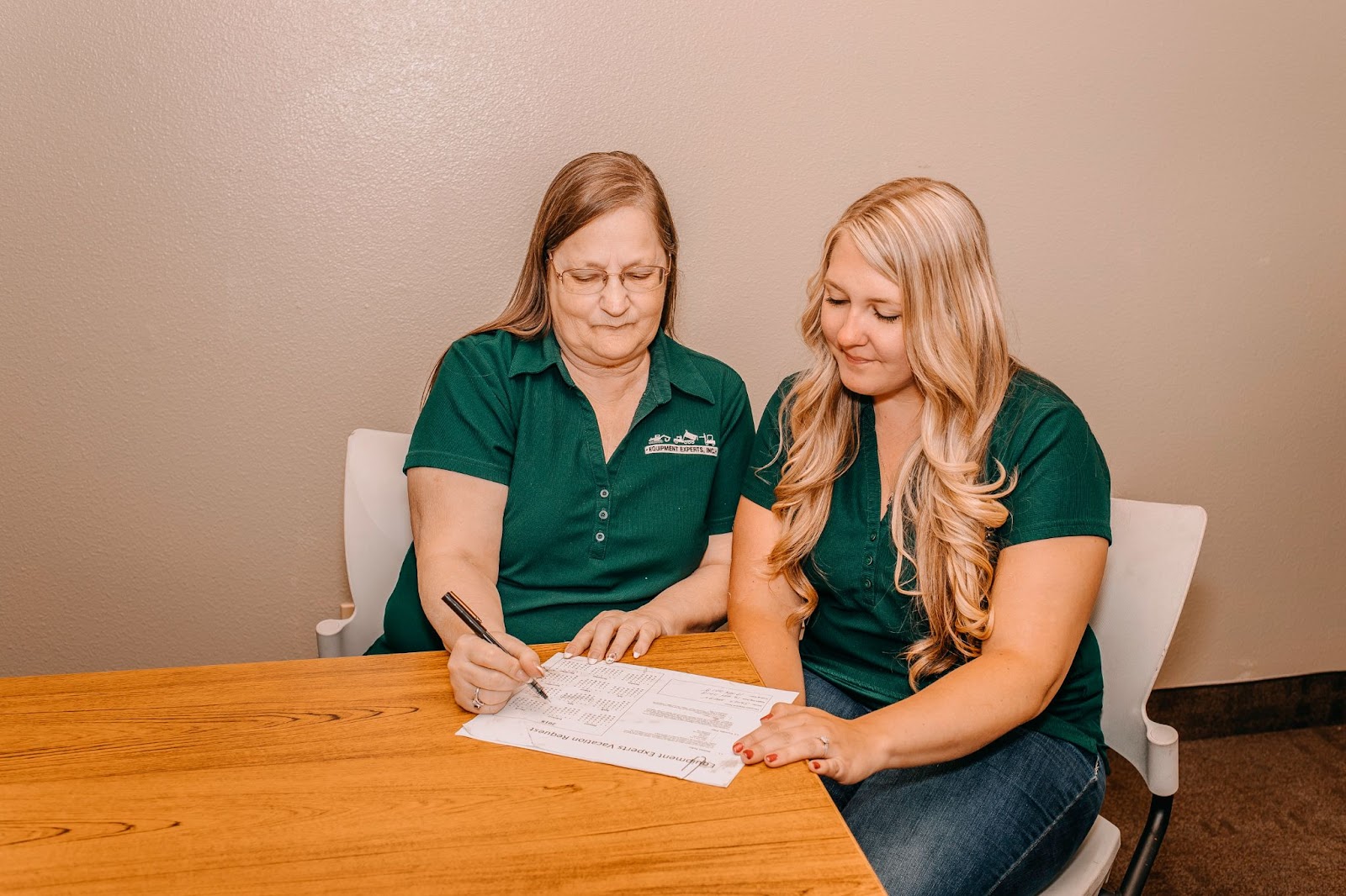 Two Equipment Expert, Inc. employees staring at a checklist on the table in front of them