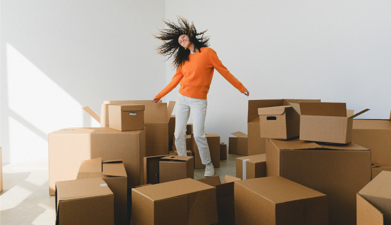 A young woman dances among a variety of cardboard boxes that she acquired for free to use during her move.