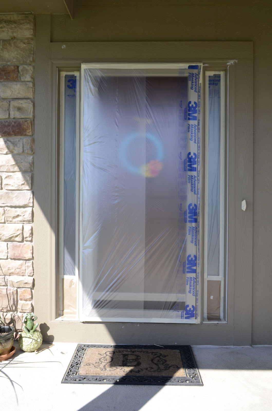 Exterior front door covered in plastic tarp in preparation for the home's exterior to be sprayed.
