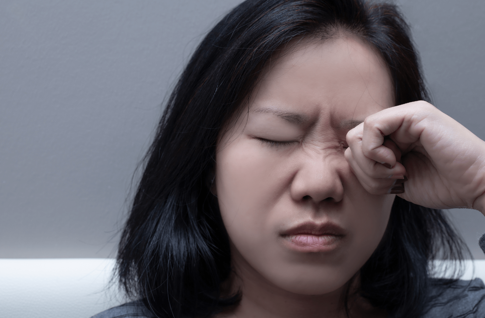 A woman rubbing her eyes due to dry eye