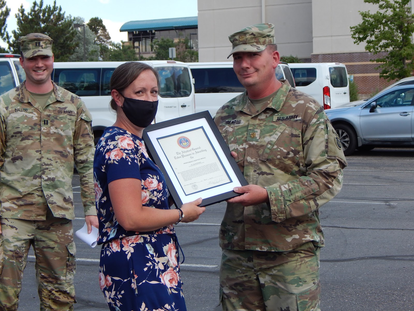 Amanda Hettinger receives her award from a US Army soldier in fatigues.