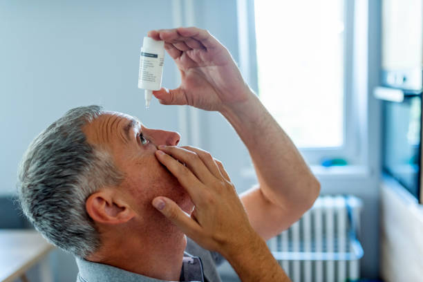 A old man dropping eye drops in his eye. This is the one of the glaucoma treatment