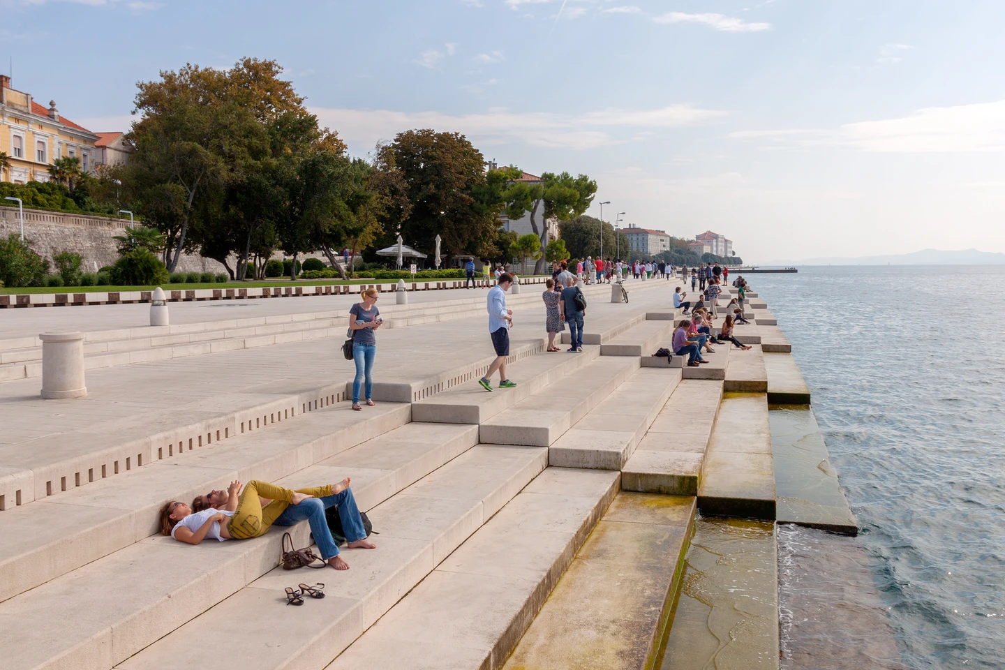 People lying on the steps, enjoying the fresh air and the music of the sea