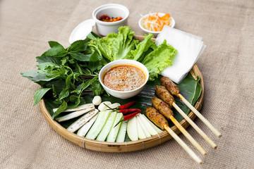 Vietnamese fermented pork roll or nem Hue with lettuce, herbs an