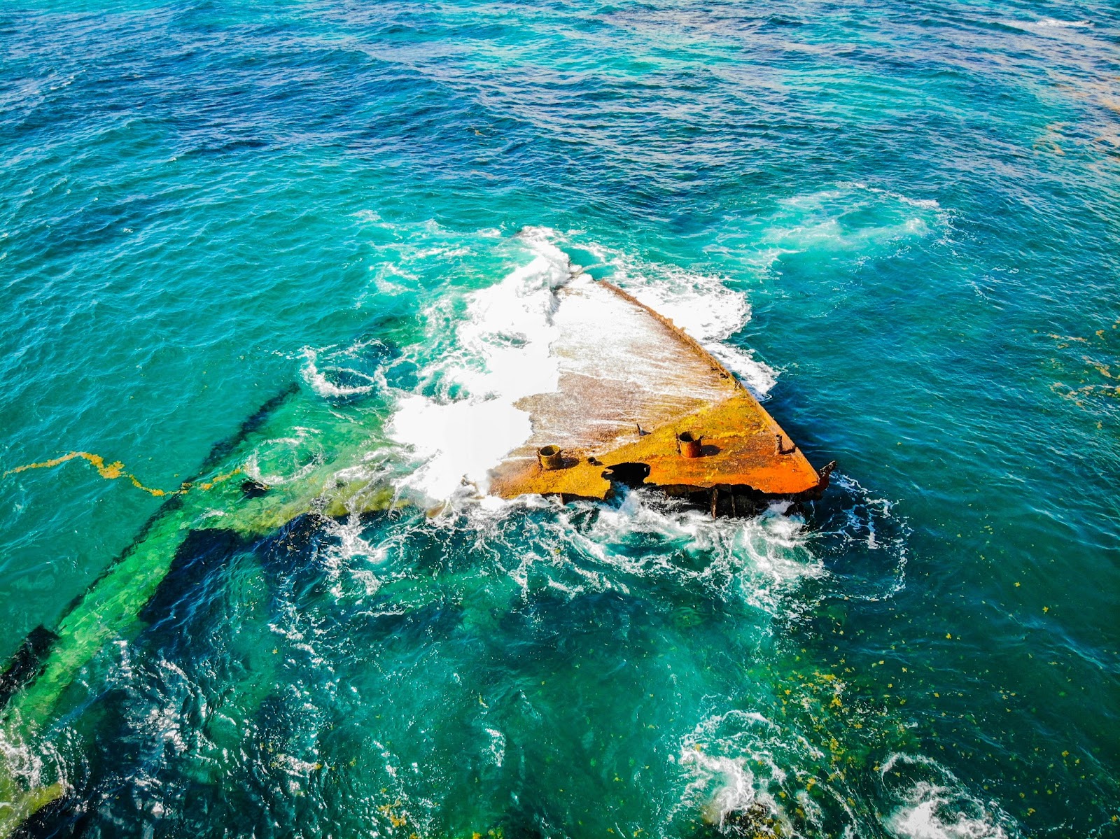 a ruined boat partially submerged underwater