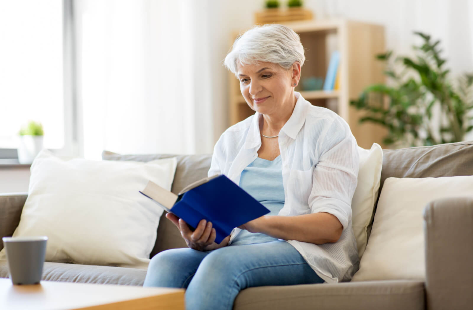 A senior woman is reading her book at ease with her multi-focal contact lenses.