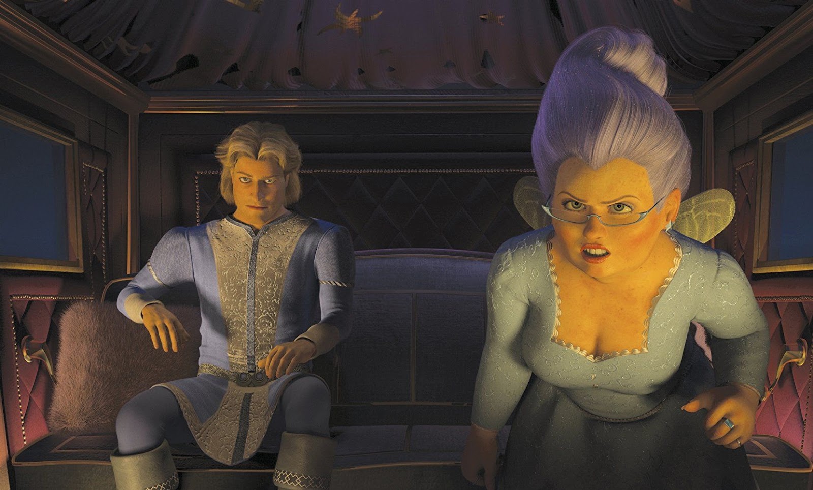 A screen still from Shrek 2, featuring Fairy Godmother and Prince Charming as the plan an evil scheme in their horse-drawn carriage. The Fairy Godmother leans in as she speaks, towards the camera.