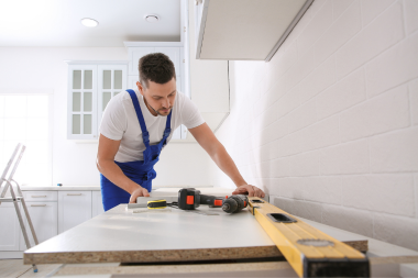 carpenter measuring materials for luxury kitchen remodel custom built