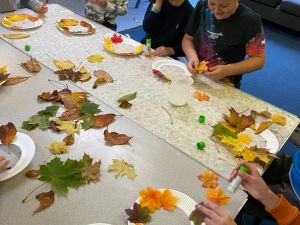 Children joyfully creating autumn arts and crafts with leaves