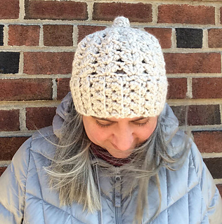 woman modeling super bulky crochet hat in front of brick wall