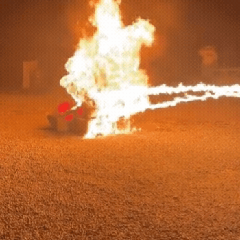 Gif of the viral video showing men using flamethrowers on boxes as a crowd cheers them on