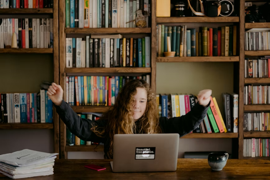 menina estudando na biblioteca com um dos tipos de tecnologias para escolas