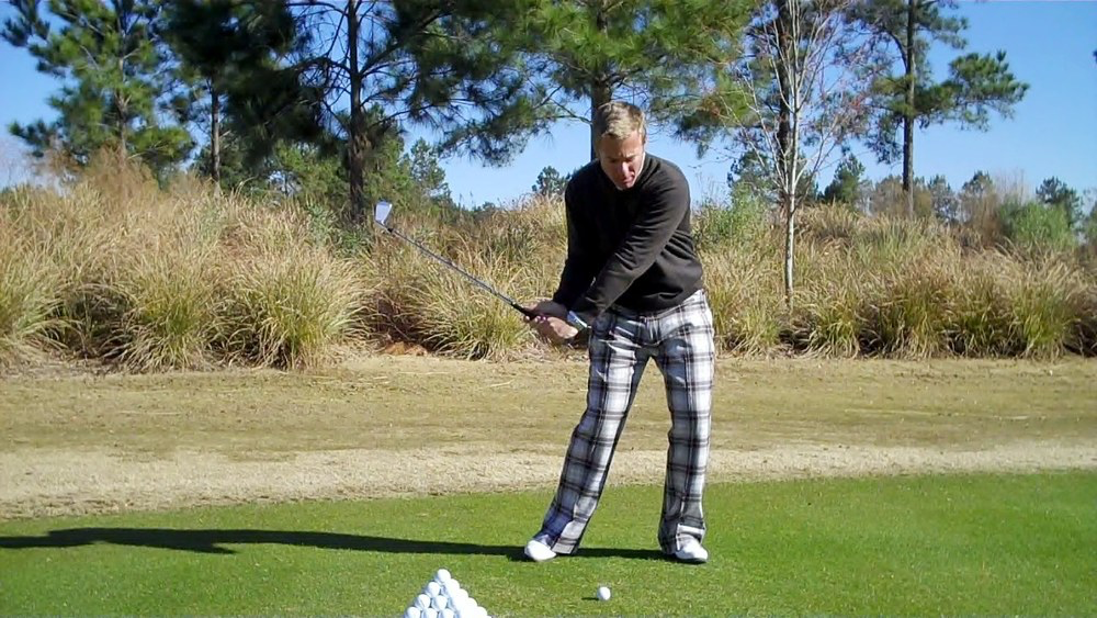 golfer ini checkered pants hitting golf ball
