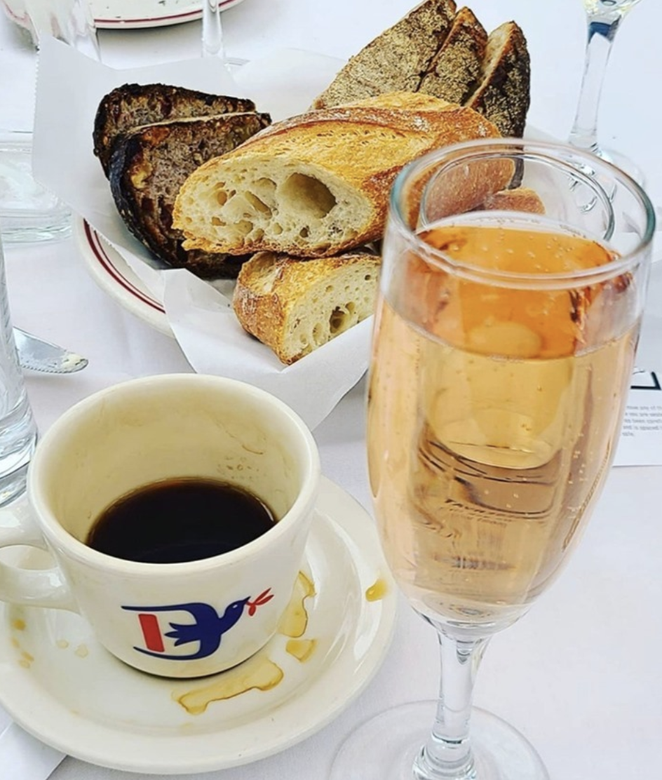 Le Diplomat brunch in DC with bread basket, coffee, and champagne