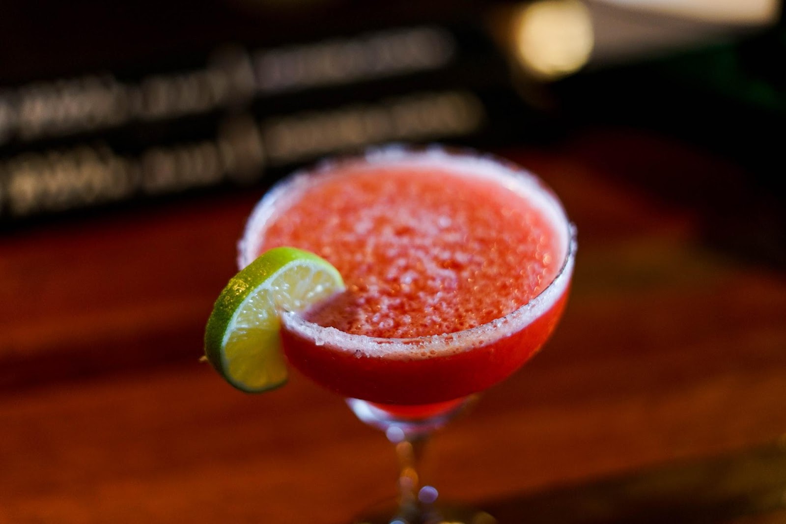 Red blended margarita with a lime wedge