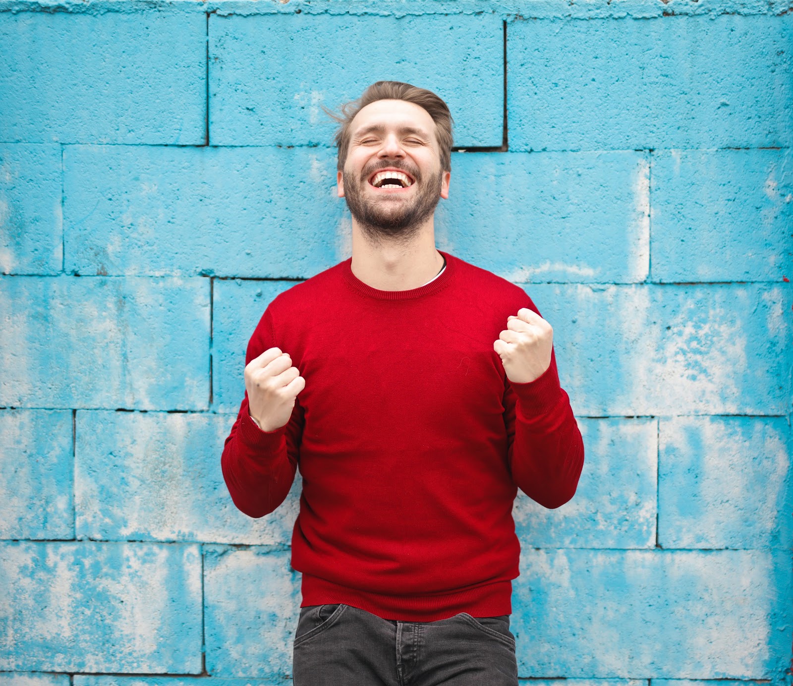 Cheerful man in front of a blue wall