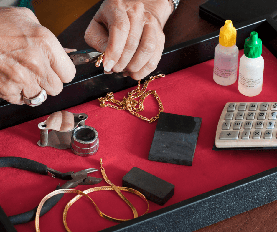 A jeweler inspects jewelry with accessories on the background