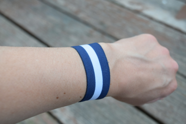 woman's arm with blue and white striped acupressure band for morning sickness