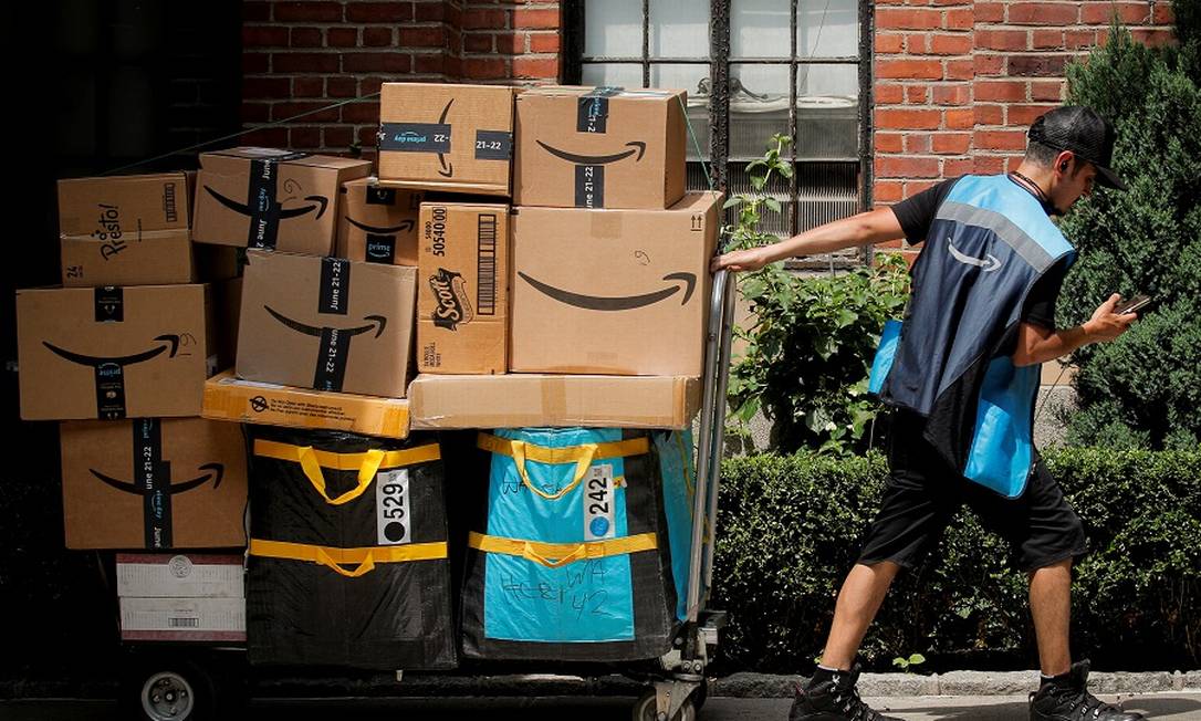 Trabalhador da Amazon com carrinho cheio de encomendas Foto: BRENDAN MCDERMID / REUTERS