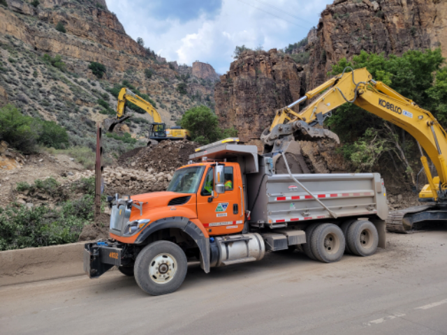 CDOT truck next to side of mountain with slide removal taking place in background