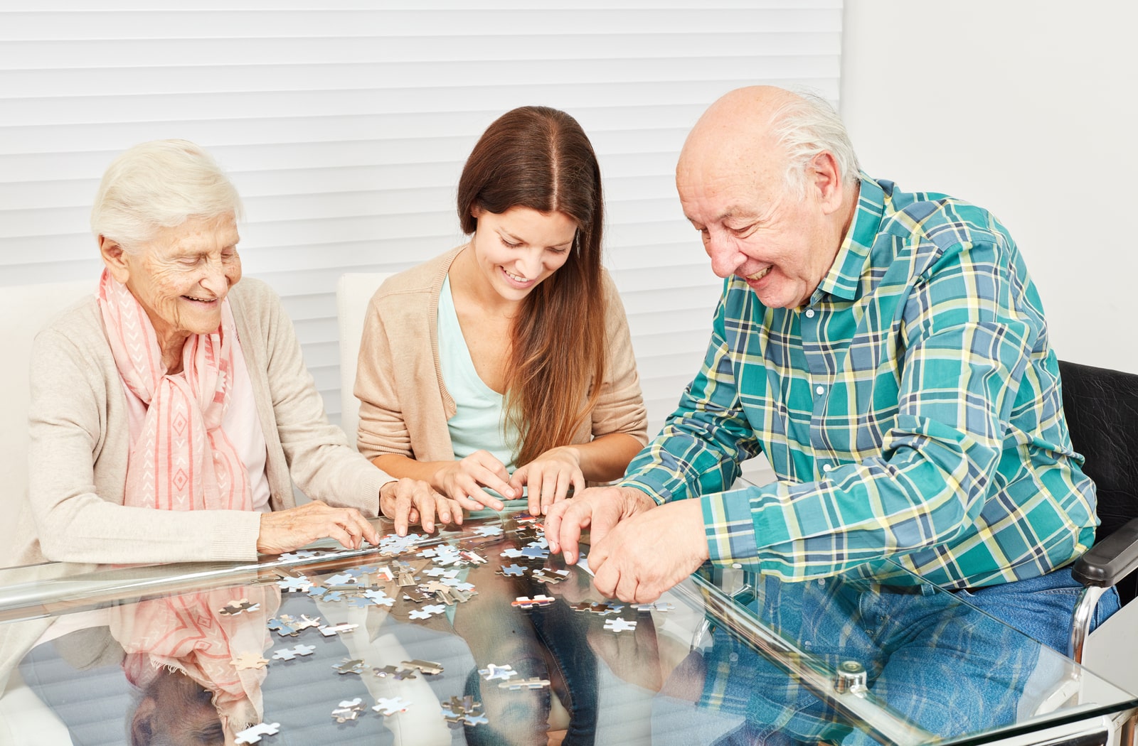 A female nurse working on a puzzle with memory care patients