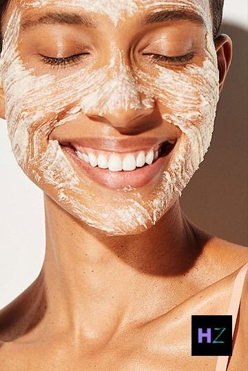 Smiling woman with white exfoliating material on her face