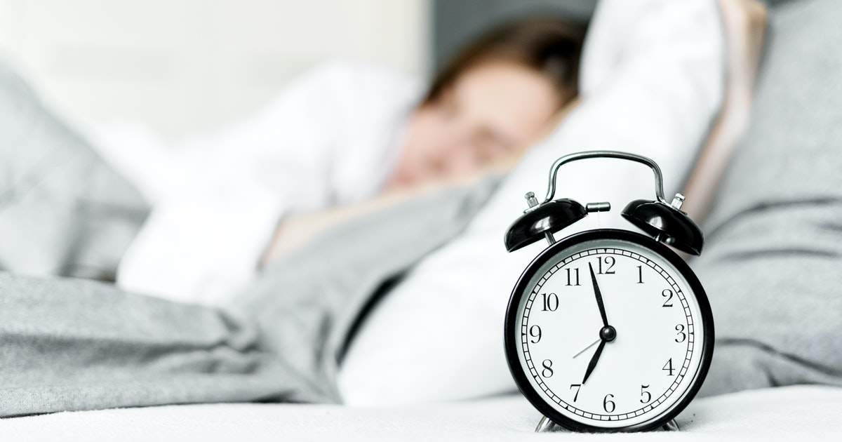 Woman sleeping next to alarm clock