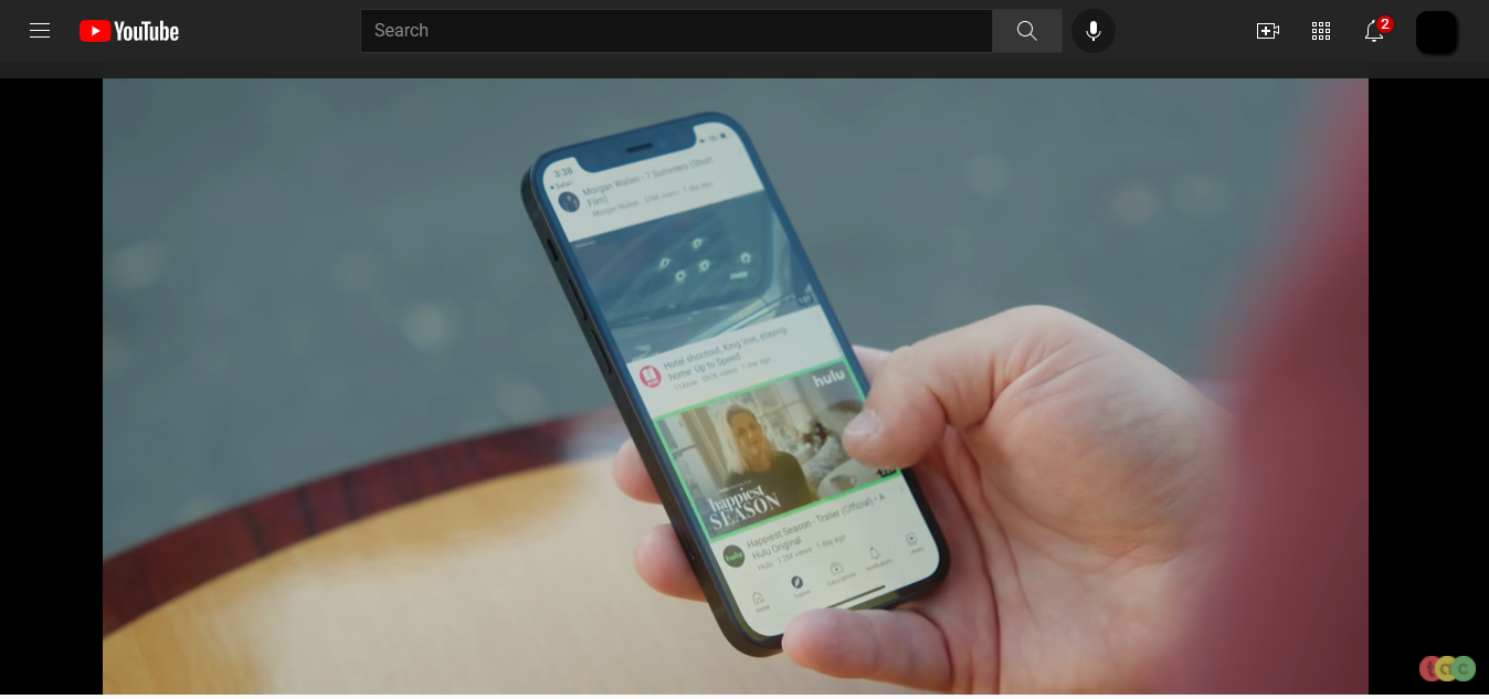 Youtube screenshot of a person holding an iPhone.