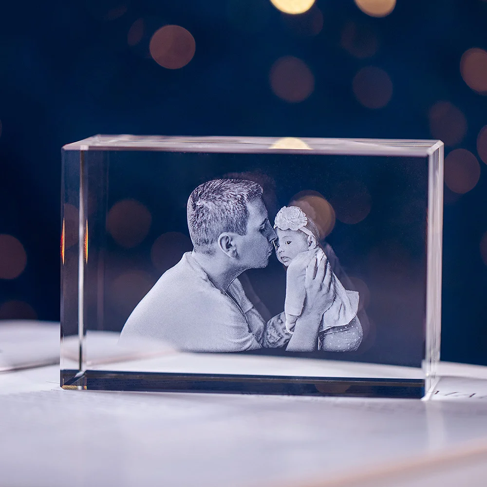 Bloc de cristal avec photographie d’un père embrassant un bébé, gravée au laser.
